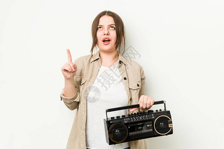 年轻的卷发女人拿着复古收音机用张开图片