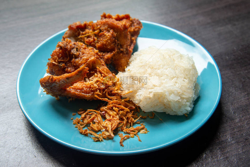 顶视图炸鸡和炸洋葱配糯米在棕色木制的浅蓝色盘子里炸鸡是泰国合艾宋卡最著名的食物文化食图片