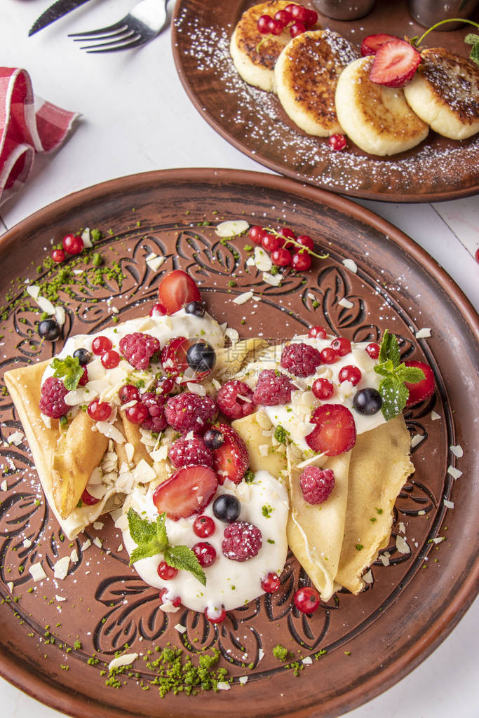 以酸奶油和浆果自制煎饼甜莓酱和白背景的乌克兰传统菜盘Top图片