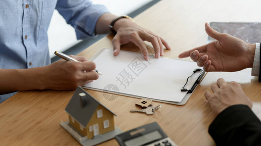 房地产客户用房屋模型和木制办公桌房钥匙签署家庭贷款协议图片