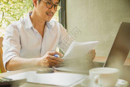 商人在办公室阅读带有业务报告的图片