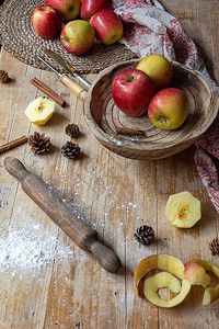 木碗厨房卷餐具肉桂面粉和垂直桌布中红色苹果的木制图片
