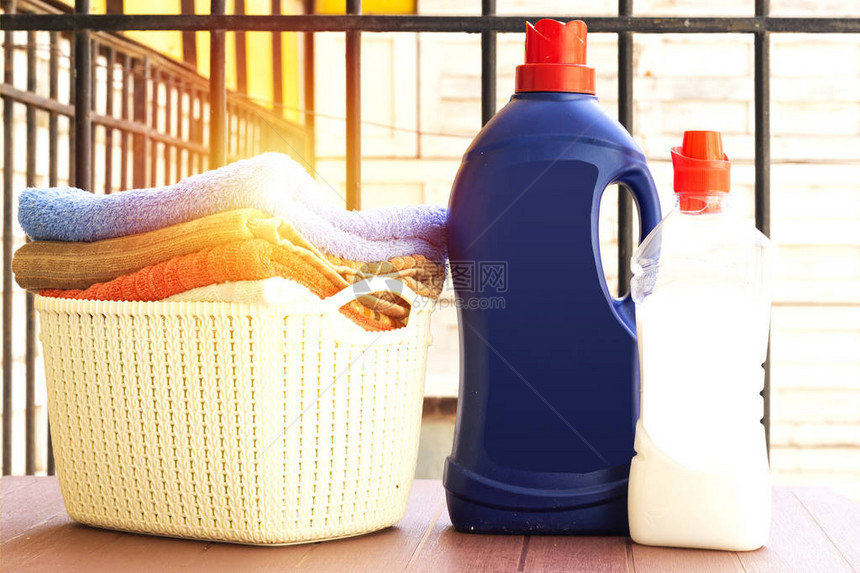 洗衣粉瓶和篮子叠干净的浴巾图片