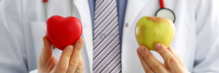 男医生胸前拿着红心和苹果健康生活和健康食品概念素食生活方式概念图片