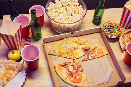 晚会桌上的披萨爆米花和酒背景图片