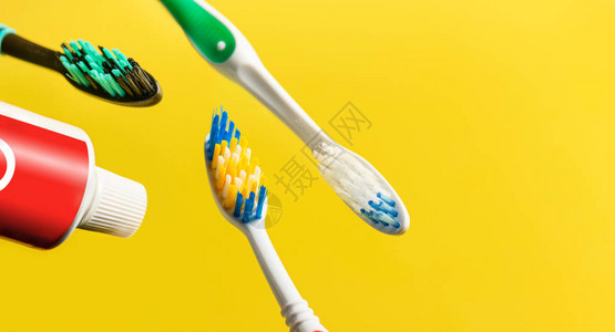 黄背景飞过牙刷和牙膏管的牙齿图片