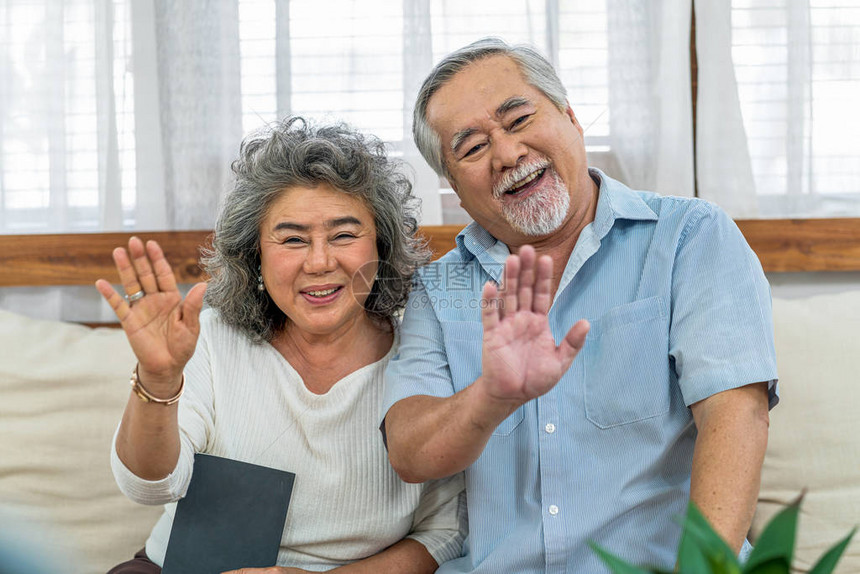 亚洲夫妇祖父母在家里通过手机视频电话问候快乐万岁和老年社会温暖的家庭图片