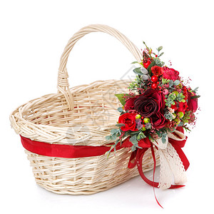 柳条篮把手上的花卉装饰用鲜红色的花朵绿色植物和丝图片