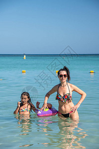 在海滩度假快乐母亲和女儿在水中妈图片