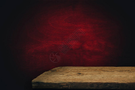 老橡木桌和红色背景墙图片