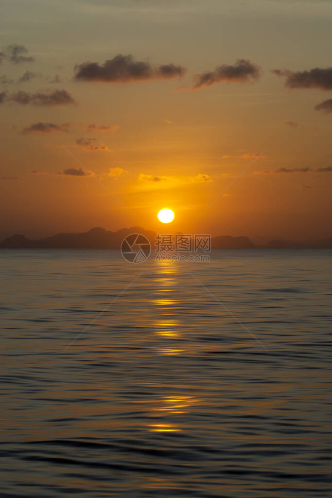 湖中日出的垂直图像有云和小太阳图片