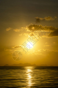 湖中日出的垂直图像有云和小太阳背景图片