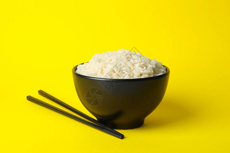 黄色背景中盛有米饭和筷子的碗文字空间图片