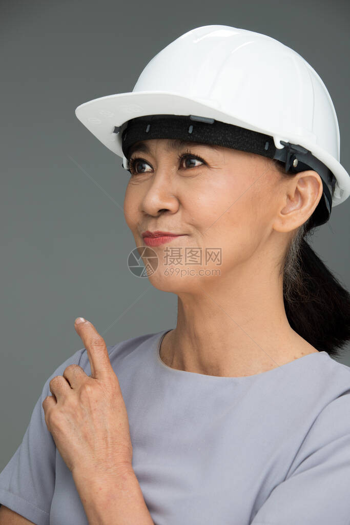 美丽的亚洲智能建筑师工程师50年代60多岁身戴白顶帽头盔的妇女望着摄影机肖像工作室照明灰色背景复制空间概念化社会图片