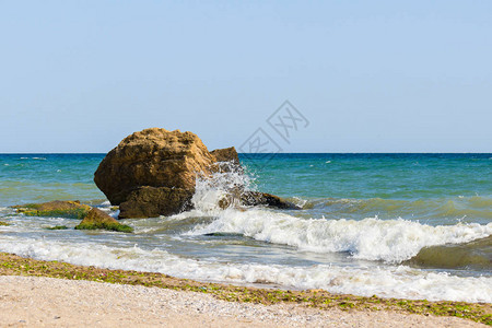 海浪冲向大石块和岩石喷洒了很多水花图片