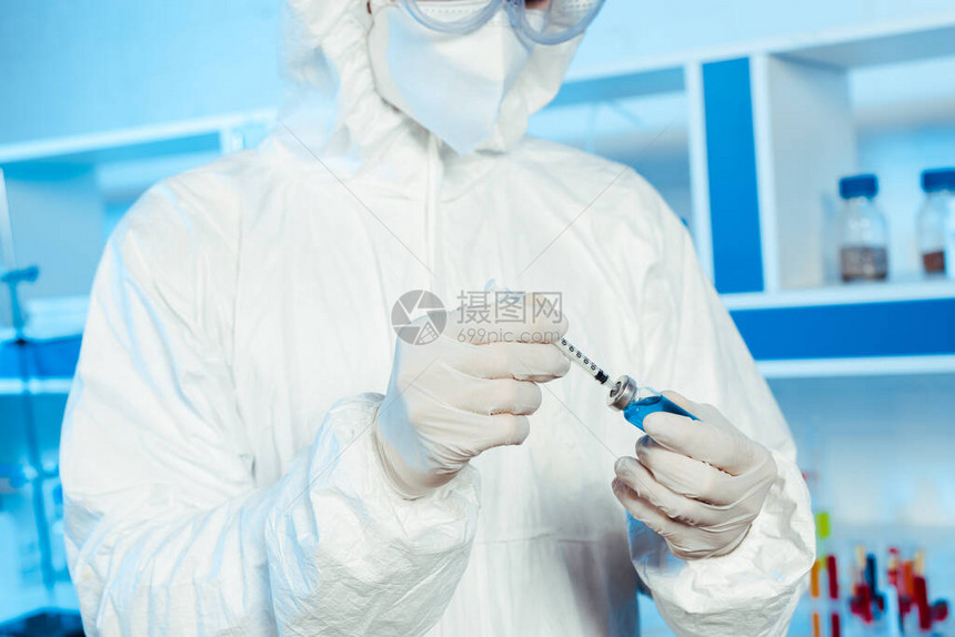 科学家对乳胶手套持有注射器和装有疫苗瓶子的针图片