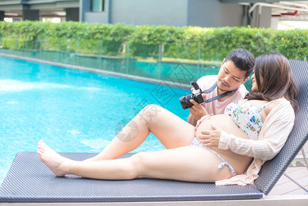有大肚子的亚洲孕妇放松和丈夫一起在图片