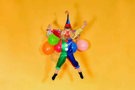 婴儿小丑在喜剧文字的背景中跳跃儿童节日的概图片