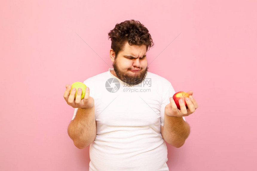 滑稽的胖男人留着胡子看着手中的苹果图片