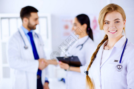 在医院微笑的年轻医生和背景检查医疗记图片