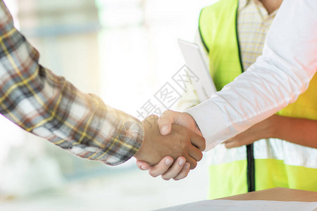 近身工程师在工地与建筑承包商握手经理成功谈判及工业图片