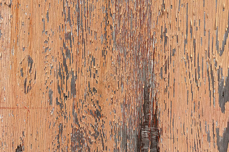 褪色剥落的橙色油漆木板的特写图片