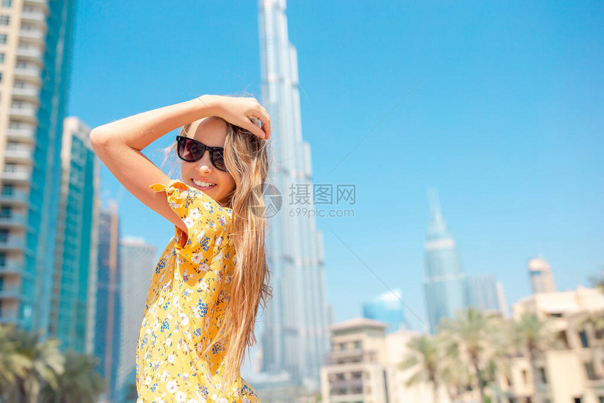 在迪拜与布吉哈利法摩天大楼一起行走的小女孩肖像从后面看校图片