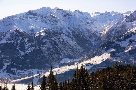 从阳光明媚的阿尔卑山高处对冬季奥地利山谷村庄图片