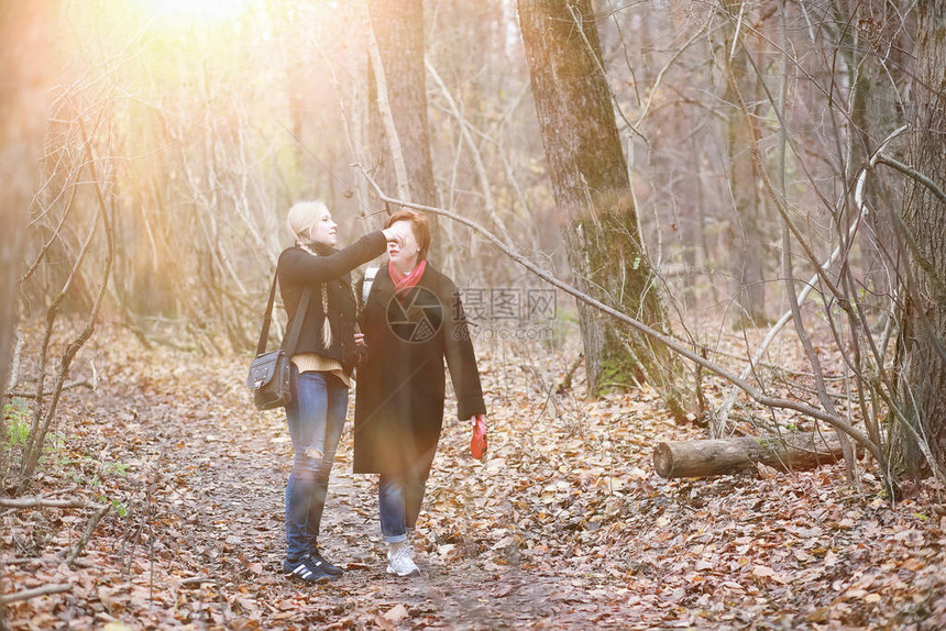 在秋天花园散步时与少女儿在一图片