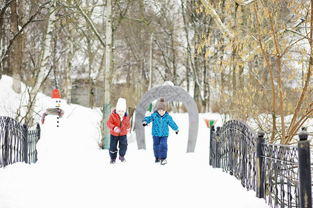 冬天公园里的孩子们孩子们在操场上玩雪他们雕刻雪背景图片