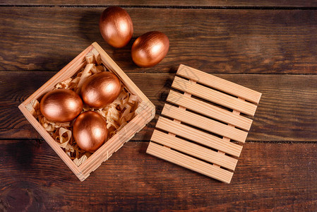 复活节鸡蛋在深木背景的礼品木箱中图片
