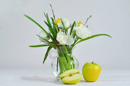玻璃vaza与一束春天的花和苹果束与柳絮和白玫瑰的褪色柳树枝母亲节背景图片