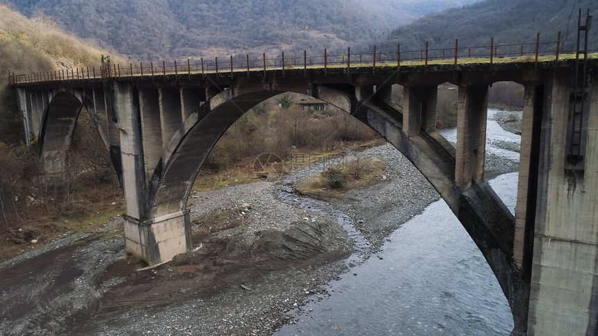 几乎干涸的河流生态问题和气候变化概念上一座废弃的旧苔藓桥的空中飞越山区的混凝土石桥图片