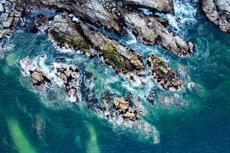 海洋波浪和岩石海岸的空中观察图片