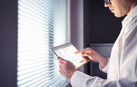 使用平板电脑的医生或商人屏幕上的电子病历或电子邮件信息认真周到的人图片