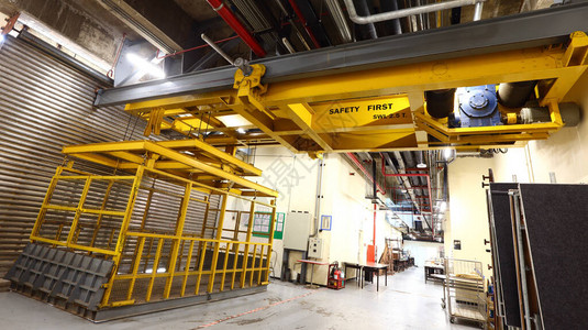 装载区的黄色电梯在建筑物或展览中心内装载重型机器图片