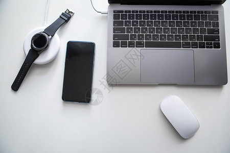 用电话脑鼠标和智能手表在白桌上的无线图片