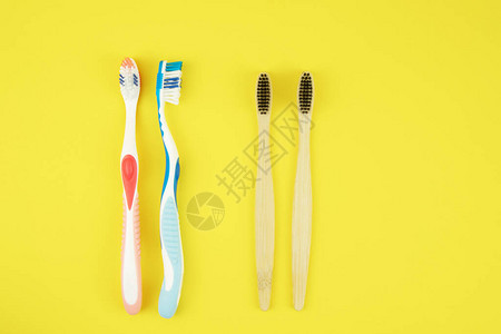 两种类型的牙刷黄色背景上的塑料和竹制天然牙刷加工产品的选择零浪图片