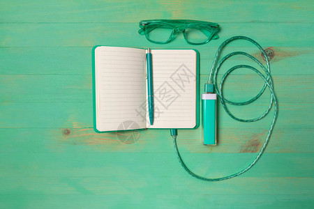 纸笔记本由电源银行笔和眼镜在木制背景上充电笑话模仿充电以图片
