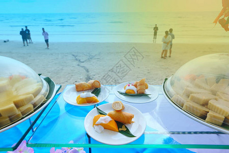 在美丽的海滩边三盘菜中与模糊的人一起吃图片