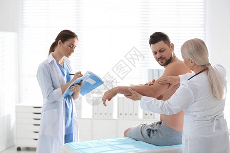 在诊所检查病人手臂的图片