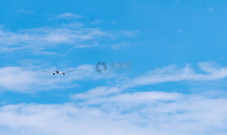商业航空公司在蓝天和白色蓬松的云彩上飞行飞机在阳光明媚的日子飞行国际航班客机后视图暑假出国旅图片