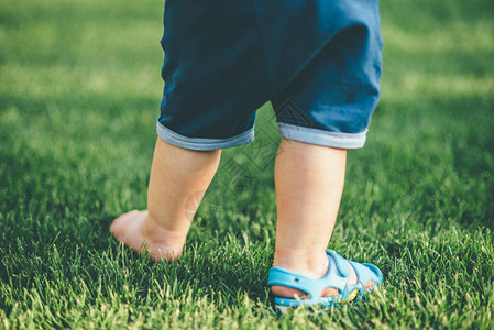 小孩穿着鞋子在草地上走近图片