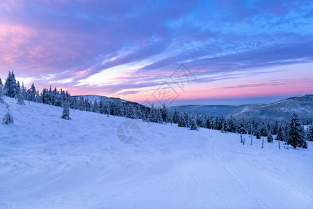 太阳升起或日落在冬季山地风景中图片