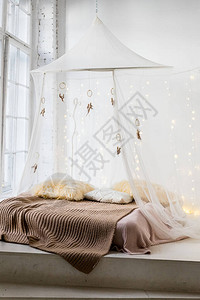 木制床头有成型被褥和白窗帘的木制床垫板上的植物背景图片