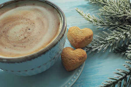 两块心形的饼干放在咖啡杯附近一个碟子上图片