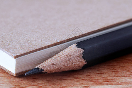 黑碳铅笔尖头办公文具木桌上带回收纸的笔记本封面文本宏背图片