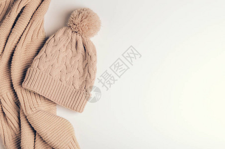 用温暖的线和米色帽子用绒球针织围巾或管子或衣领秋冬配饰复制空间图片
