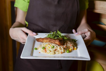炒肉配米饭和蔬菜服务员在餐厅里拿着一盘食物在餐厅或咖啡厅服务穿着图片
