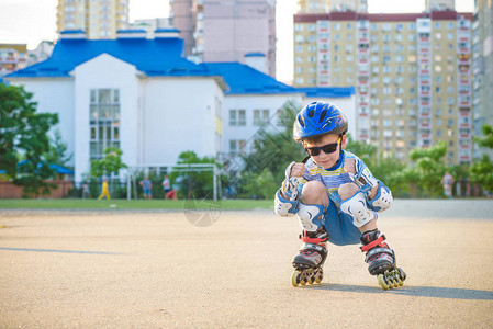 小男孩夏天在公园坐过山车戴头盔的快乐孩高清图片